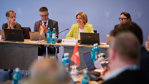 Malu Dreyer und weitere Teilnehmer sitzen am runden Tisch