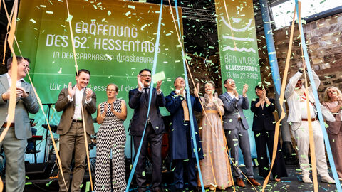 Bürgermeister Sebastian Wysocki, Staatskanzlei-Chef Benedikt Kuhn, Tanja Raab-Rhein, Ministerpräsident Boris Rhein, das Hessentagspaar Matthias Kallmeyer und Ena Kaufmann sowie Landrat Jan Weckler (v. l. n. r.) feiern die Eröffnung des Hessentages.