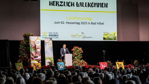 Ministerpräsident Boris Rhein steht vor einer Menge Menschen und hält eine Rede.