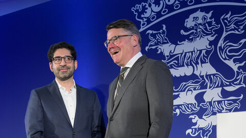 Boris Rhein und Kaweh Mansorri  mit neuem Logo im Hintergrund.